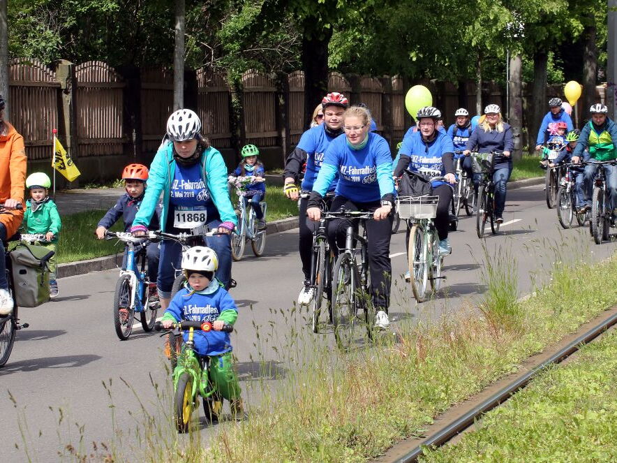 Eine Gruppe Erwachsener und Kinder fährt auf einer Straße mit dem Fahrrad