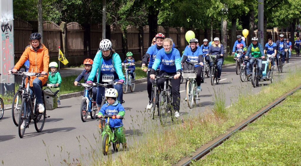 Eine Gruppe Erwachsener und Kinder fährt auf einer Straße mit dem Fahrrad